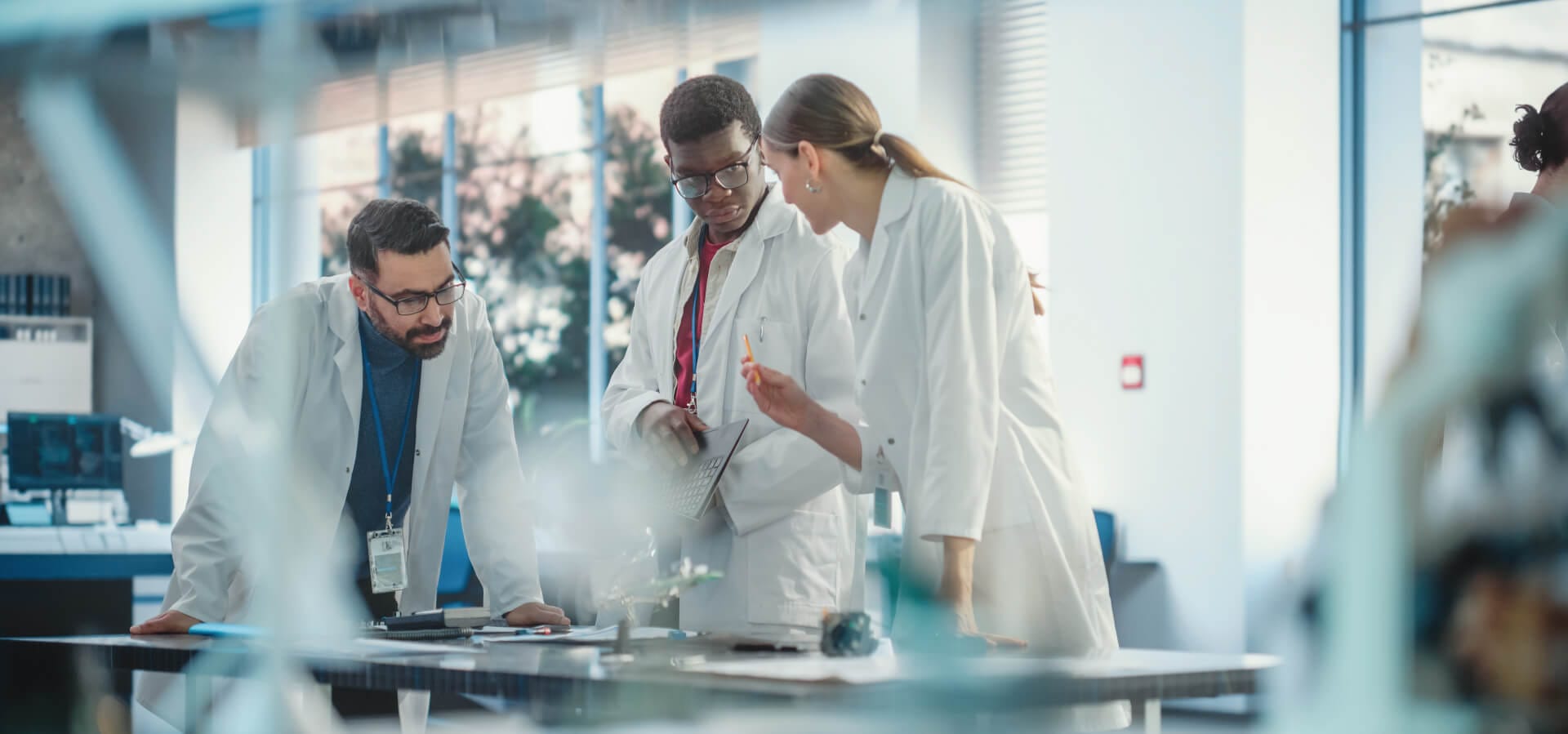 Scientists talking together around a lab table